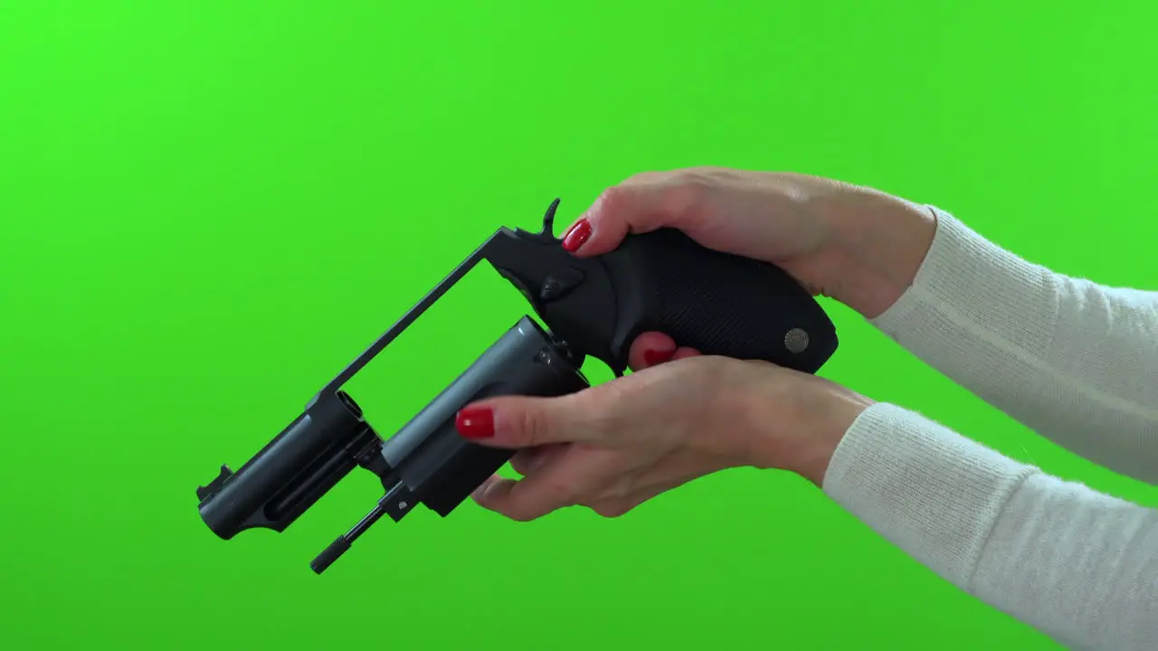 Close up of woman checking handgun for ammo cocking de-cocking on green screen