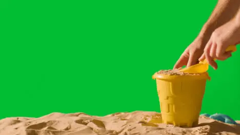 Summer Holiday Concept Making Sandcastle On Sandy Beach Against Green Screen