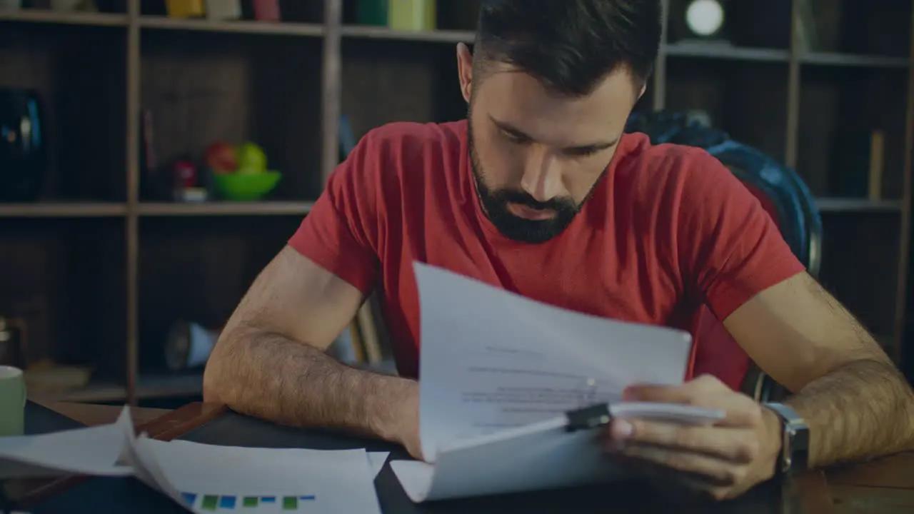 Young business man working with pen with business documents in office at evening