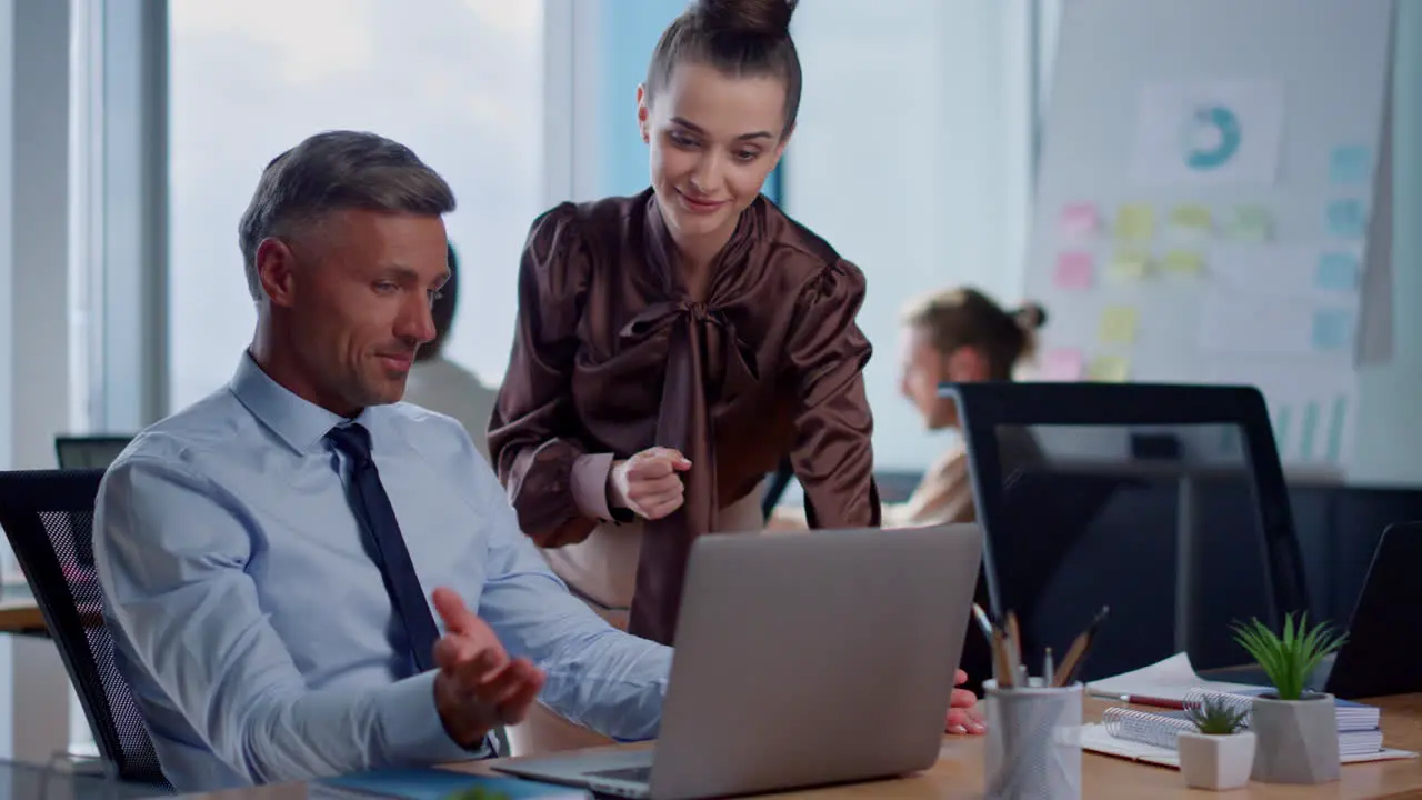 Cheerful businesswoman and businessman brainstorming in open space