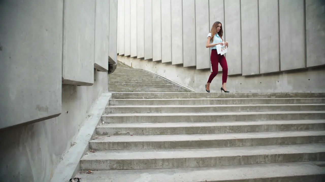 Businesswoman working with documents in city Female manager walking down stairs