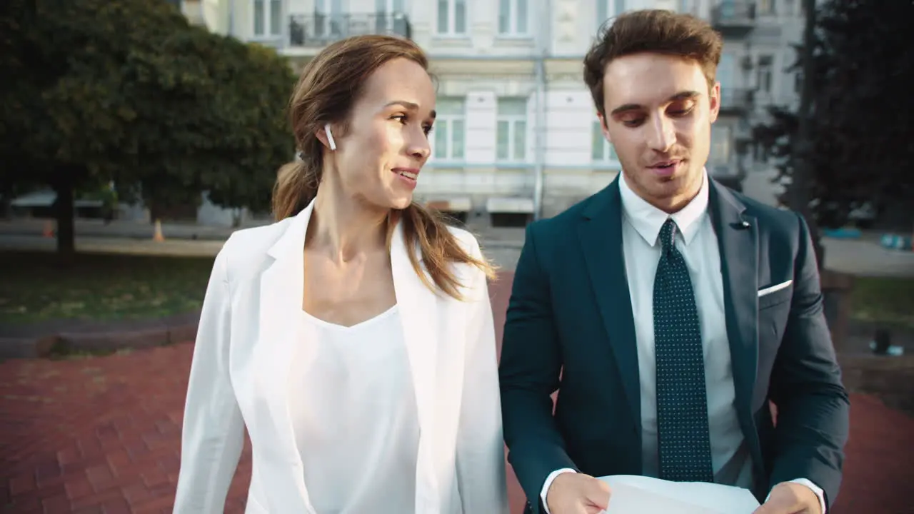 Friendly business man and lady talking about documents on street walk