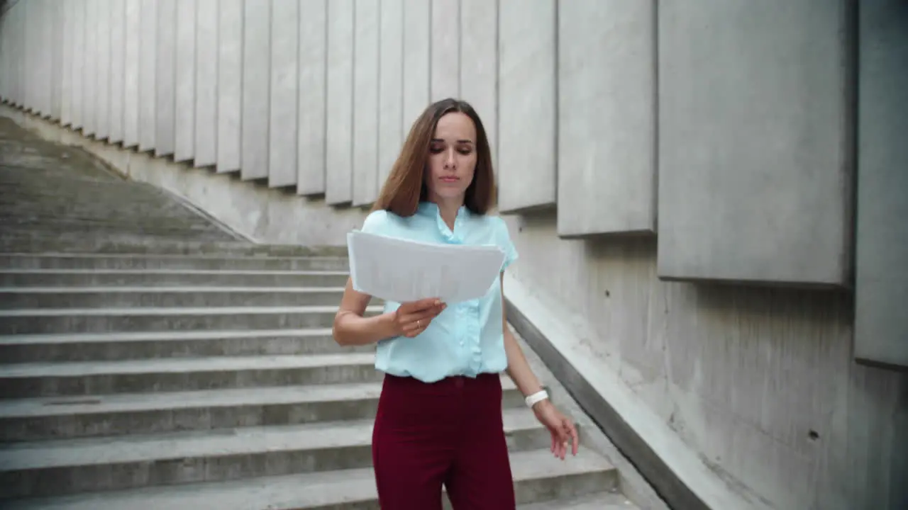 Attractive businesswoman holding business papers Busy woman running downstairs