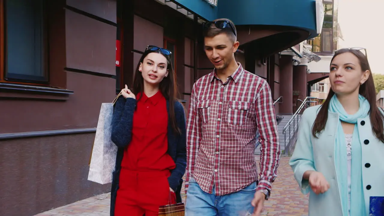 Steadicam Shot Friends Two Women And A Man Walking Down The Street With Shopping Bags