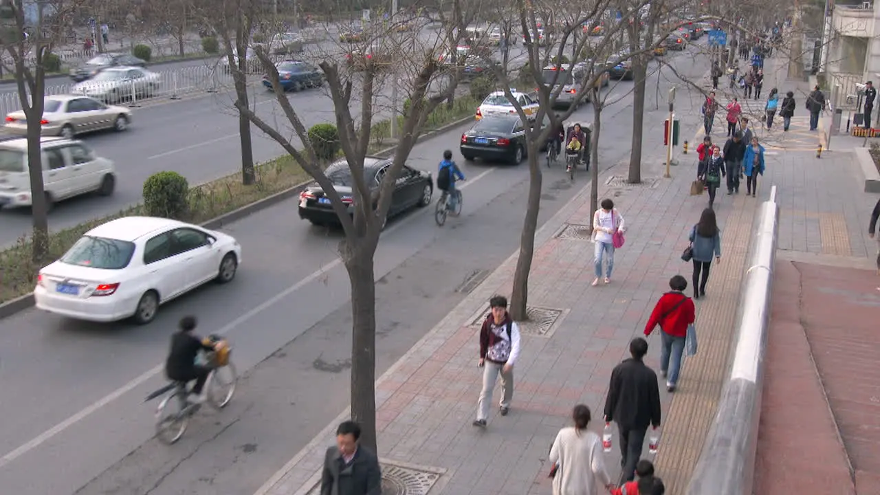 A high angle over a Beijing China street with modern traffic and pedestrians