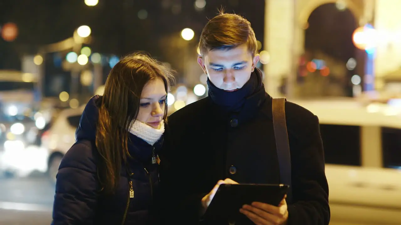 A young couple uses a tablet for directions