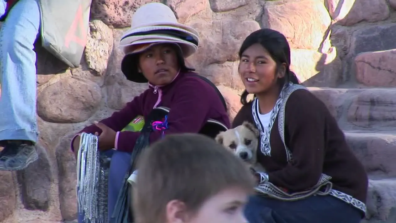 Latin American souvenir sellers hold a dog at a tourist attraction in South America