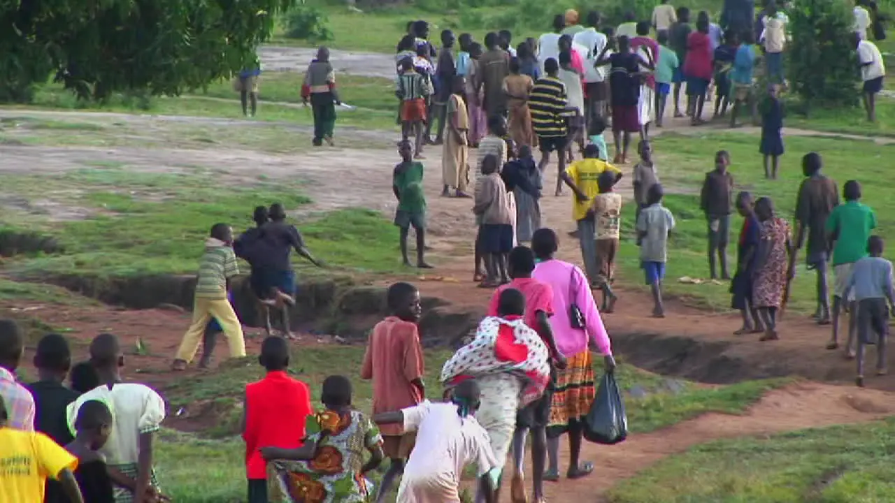 Longshot of African children run down a country road