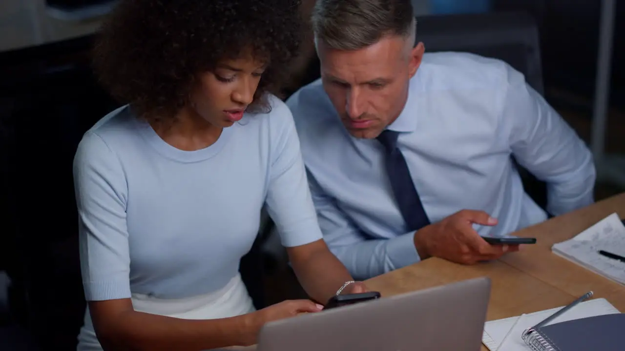 Focused man and woman looking smartphones at workplace Business couple working