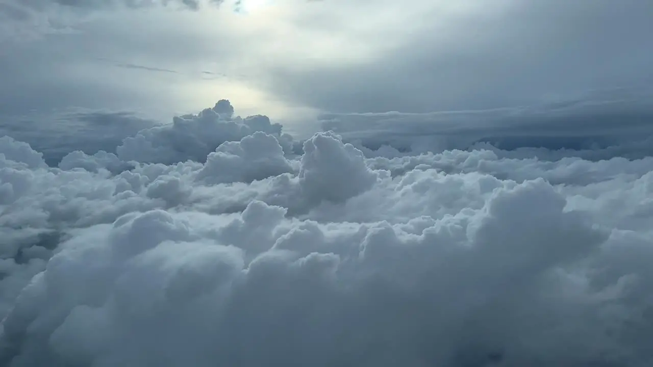 Aerial view taken from a jet cockpit of some cumulus clouds lateral side with a nice afternoon sky