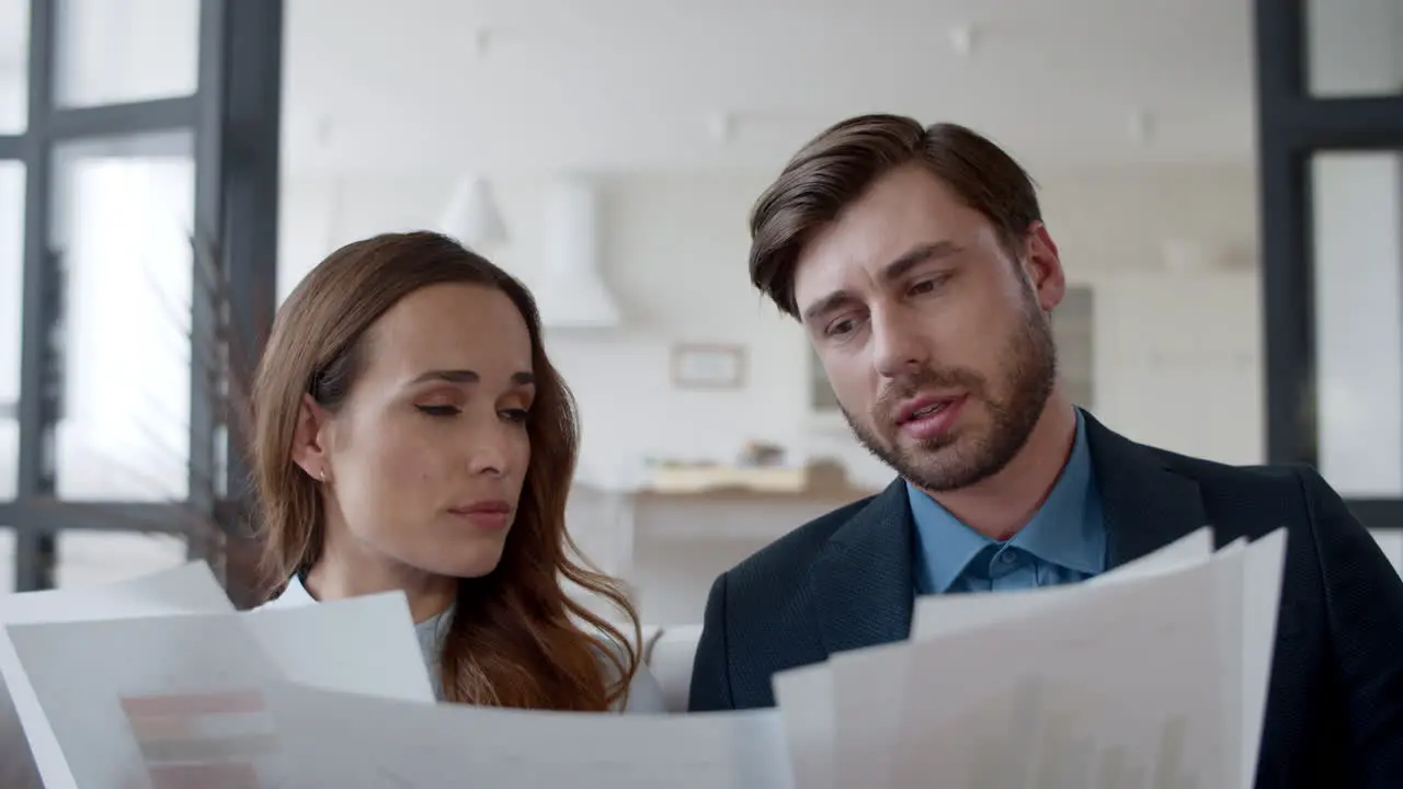 Closeup focused couple reading documents at home Partners discuss graphics