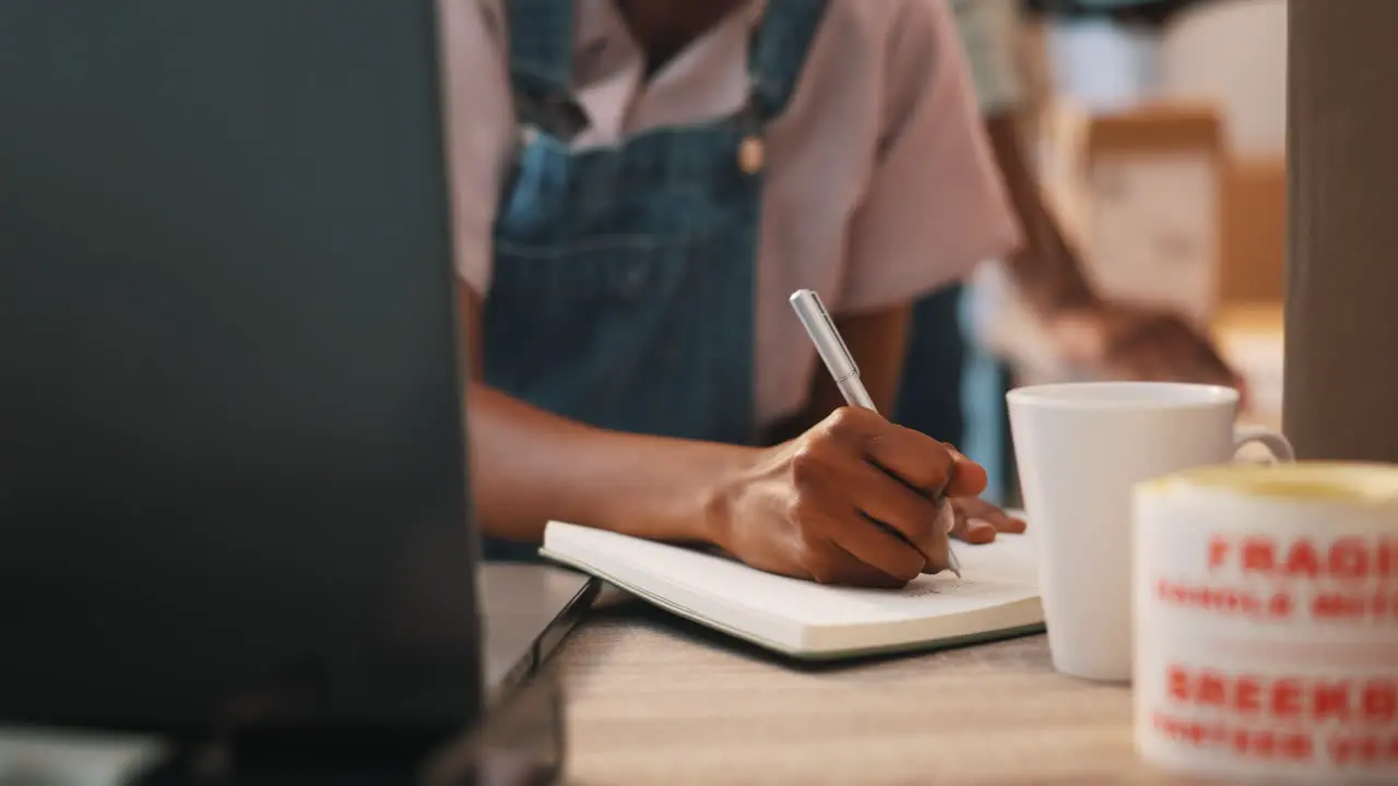 Ecommerce laptop and black woman writing notes