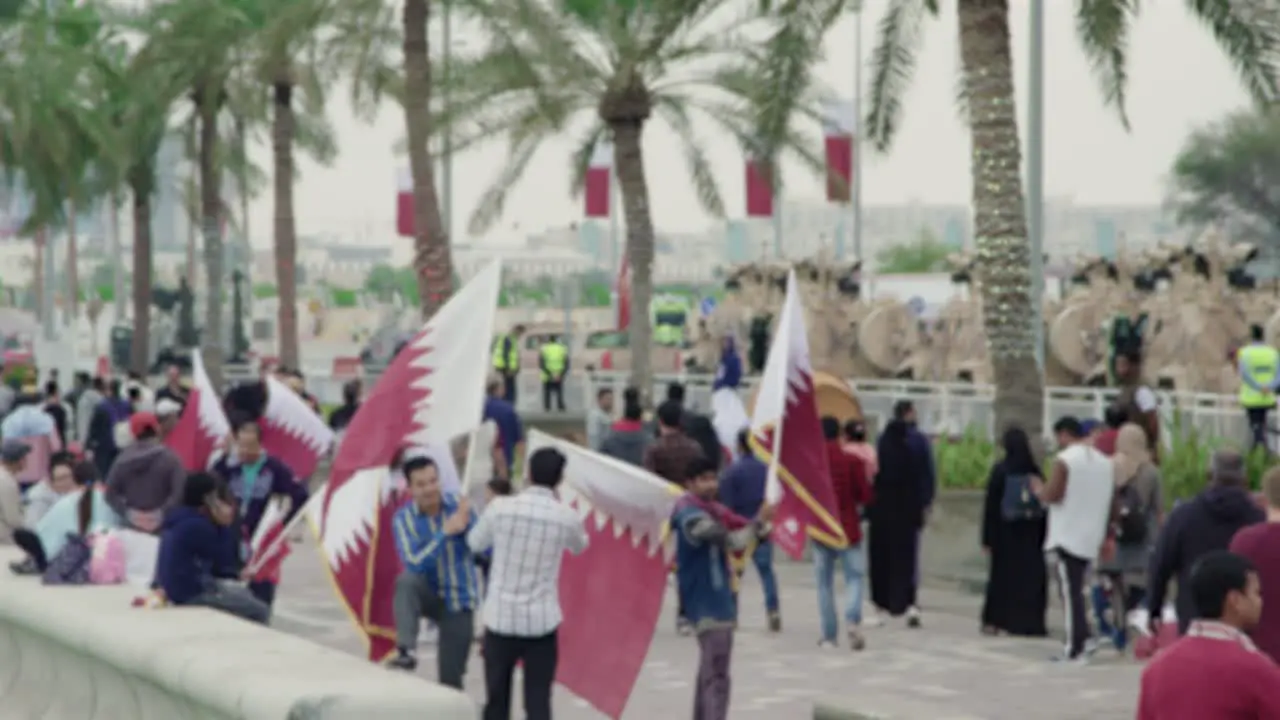 People waiving Flags in slow motion on Qatar National day in corniche Doha