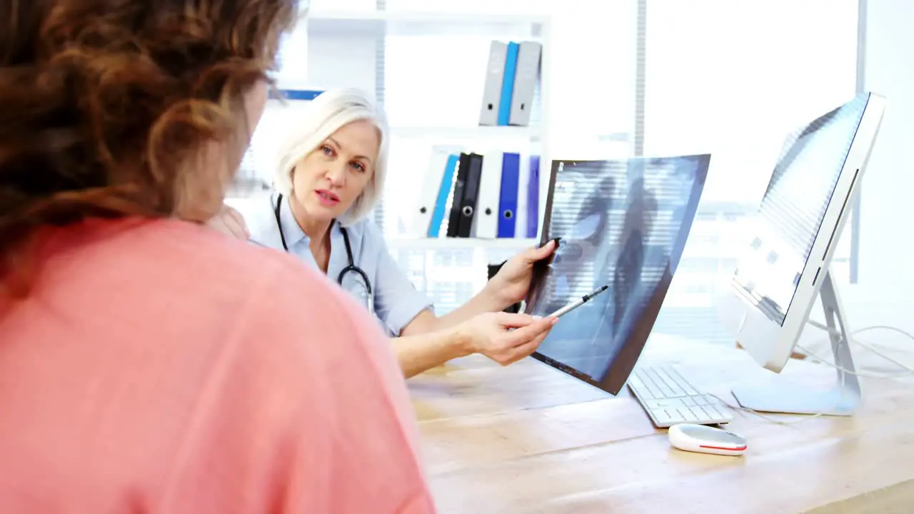 Female doctor and patient looking at x-ray