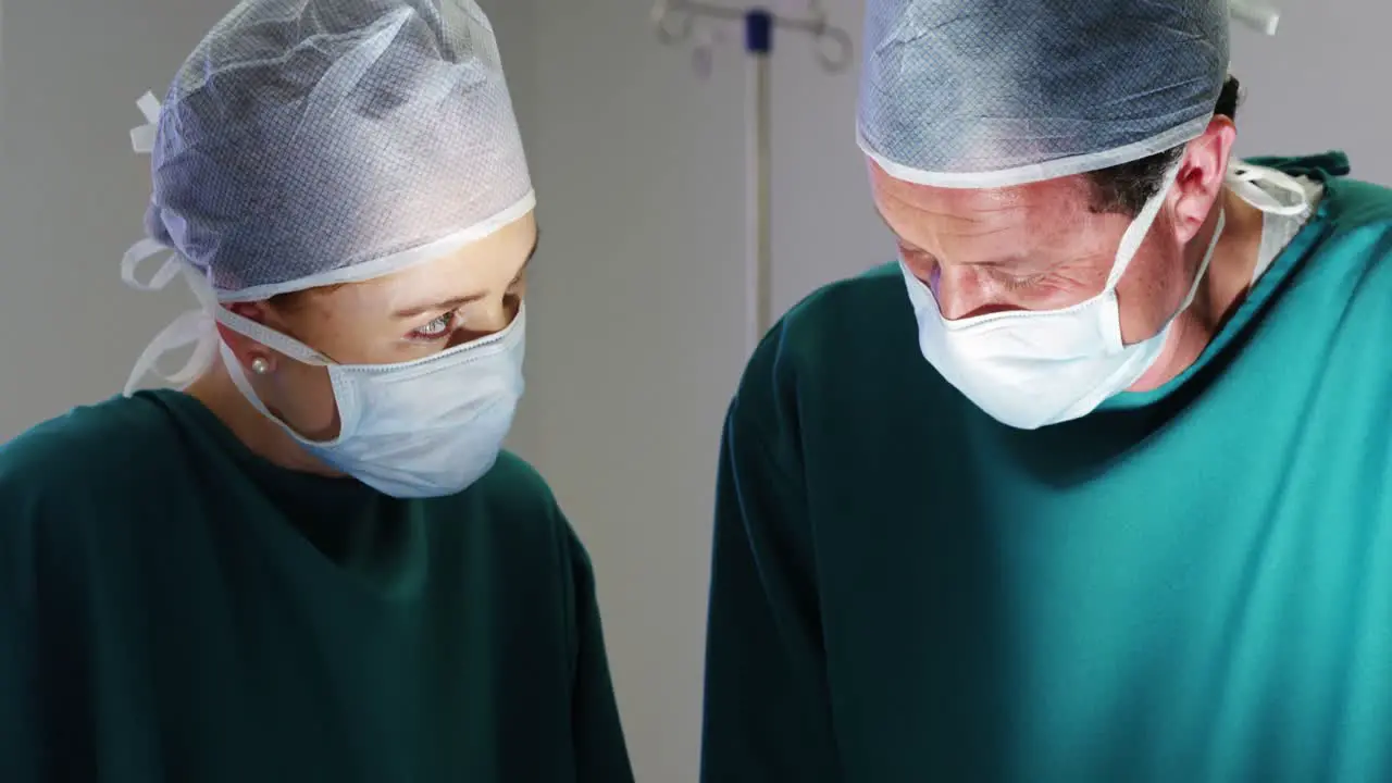 Surgeons interacting with eachother while performing operation in operation room