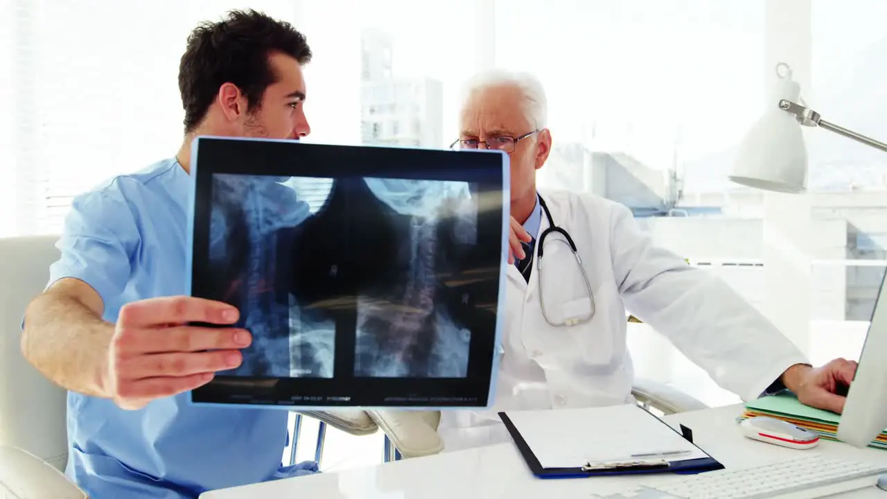 Male doctor and coworker examining x-ray