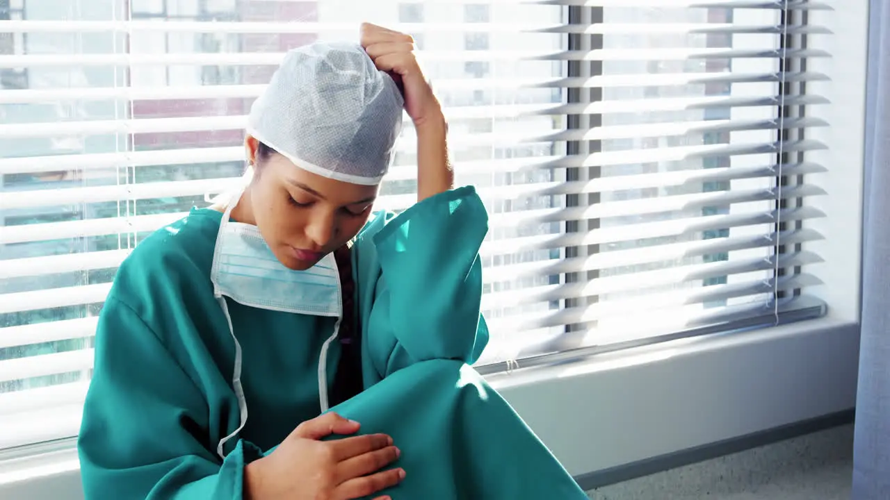 Sad nurse sitting on the floor