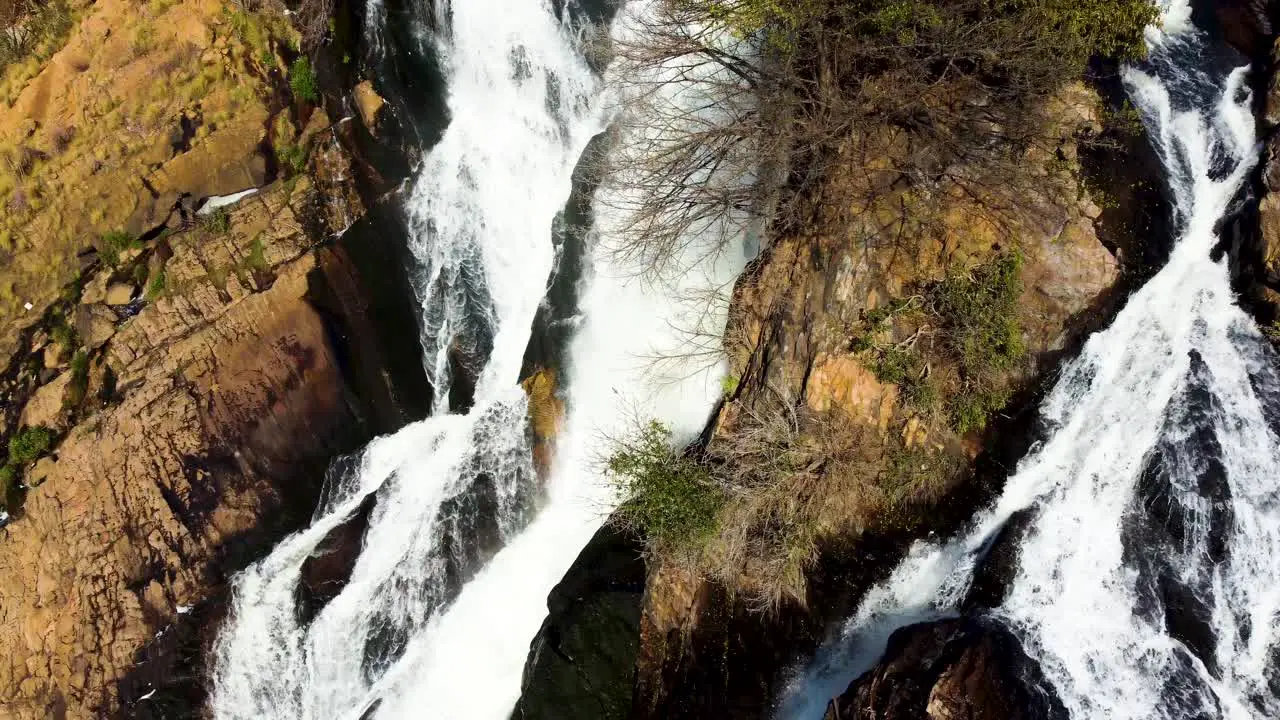 A stream of water flowing down African rocks creating a small waterfall in Hartebeesport Dam North West South Africa