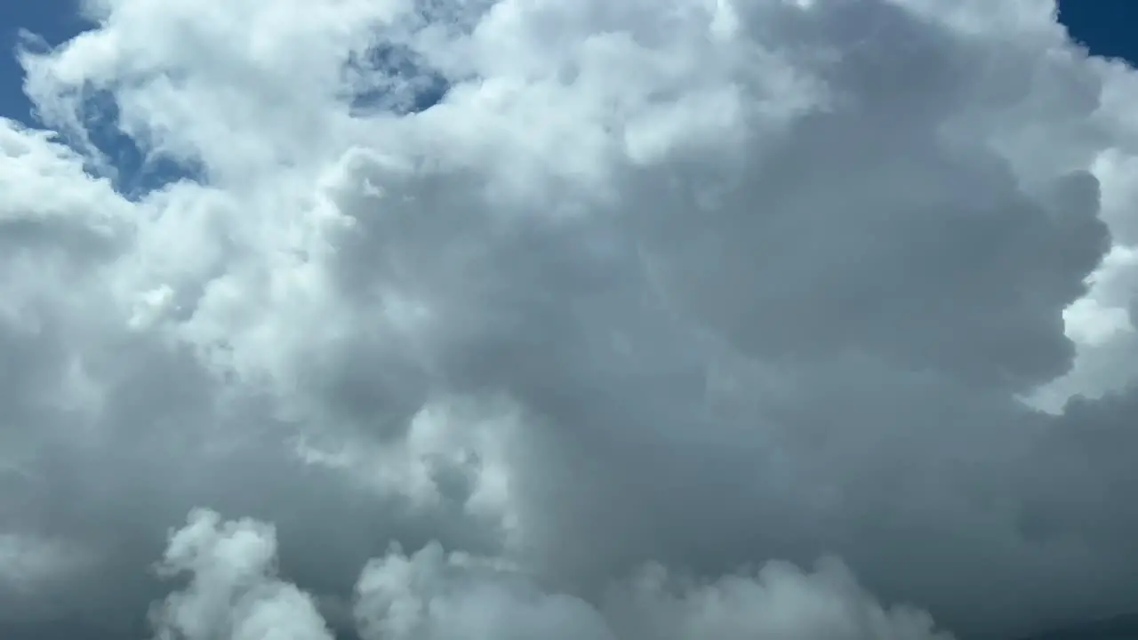 Unique Pilot POV from a jet cockpit while flying between very high stormy clouds at 12000 metres