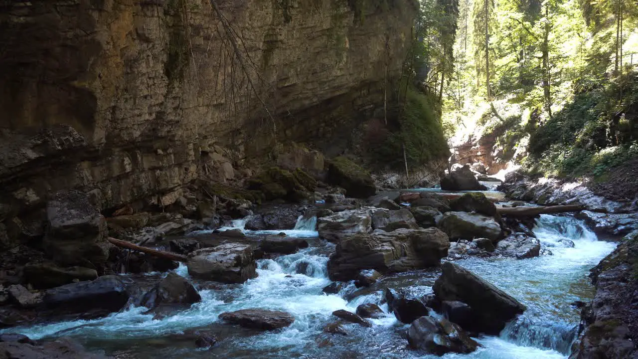 a blue cold and clear mountain river flows through a gorge in the alps water foams up