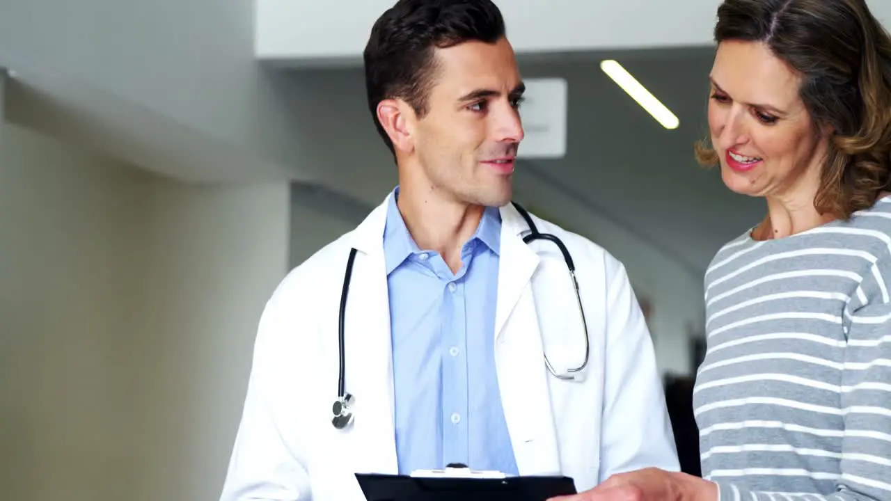 Mother and doctor discussing over clipboard