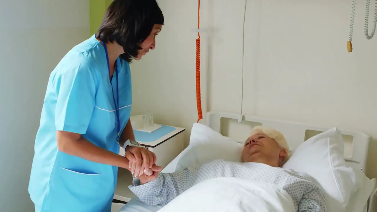 Nurse consoling senior patient with doctor