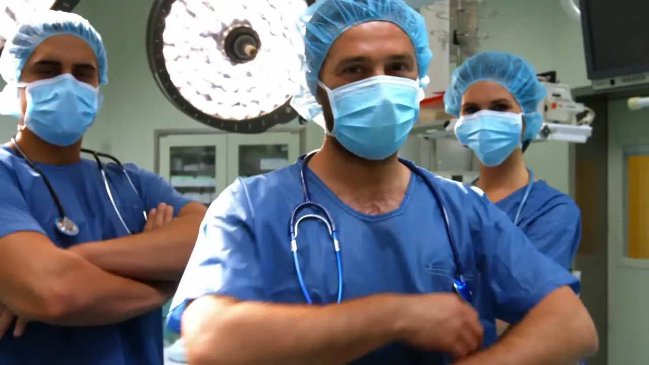 Portrait of male and female surgeons with arms crossed in operation room