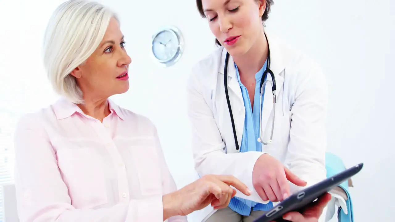 Female doctor and colleague discussing over digital tablet