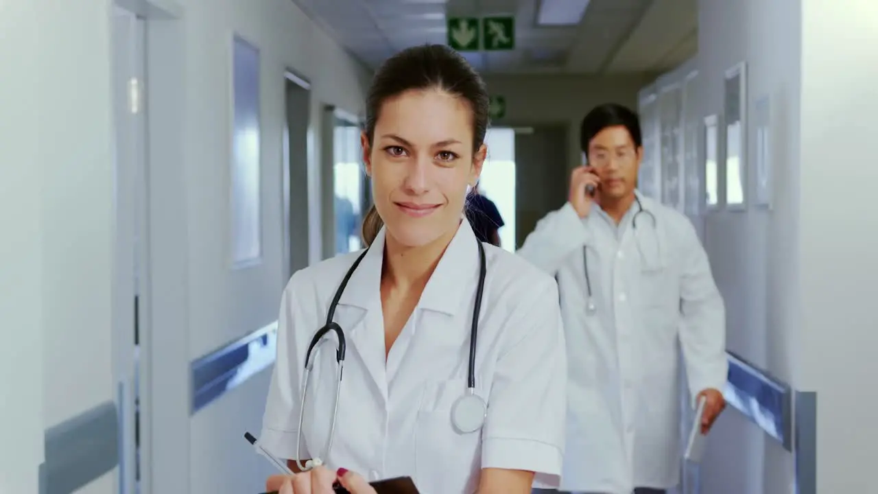 Female doctor standing in the corridor at hospital 4k