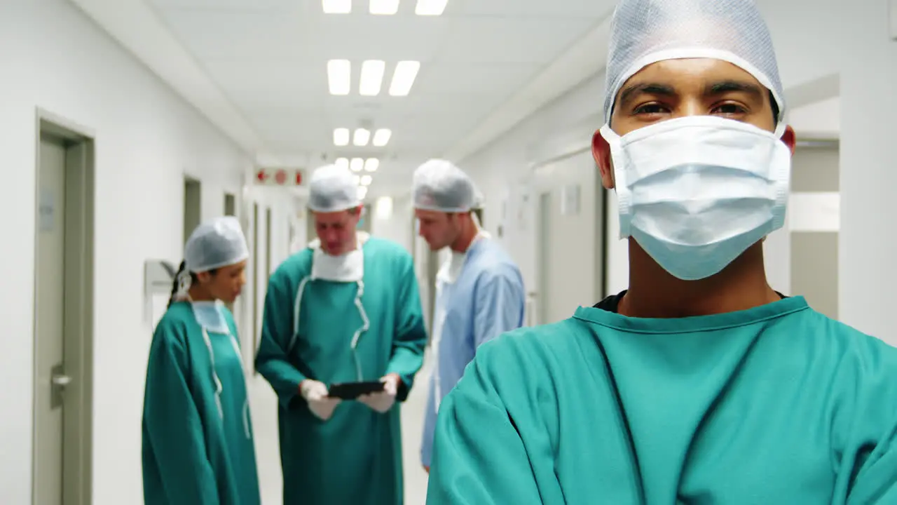 Portrait of male surgeon standing with arms crossed