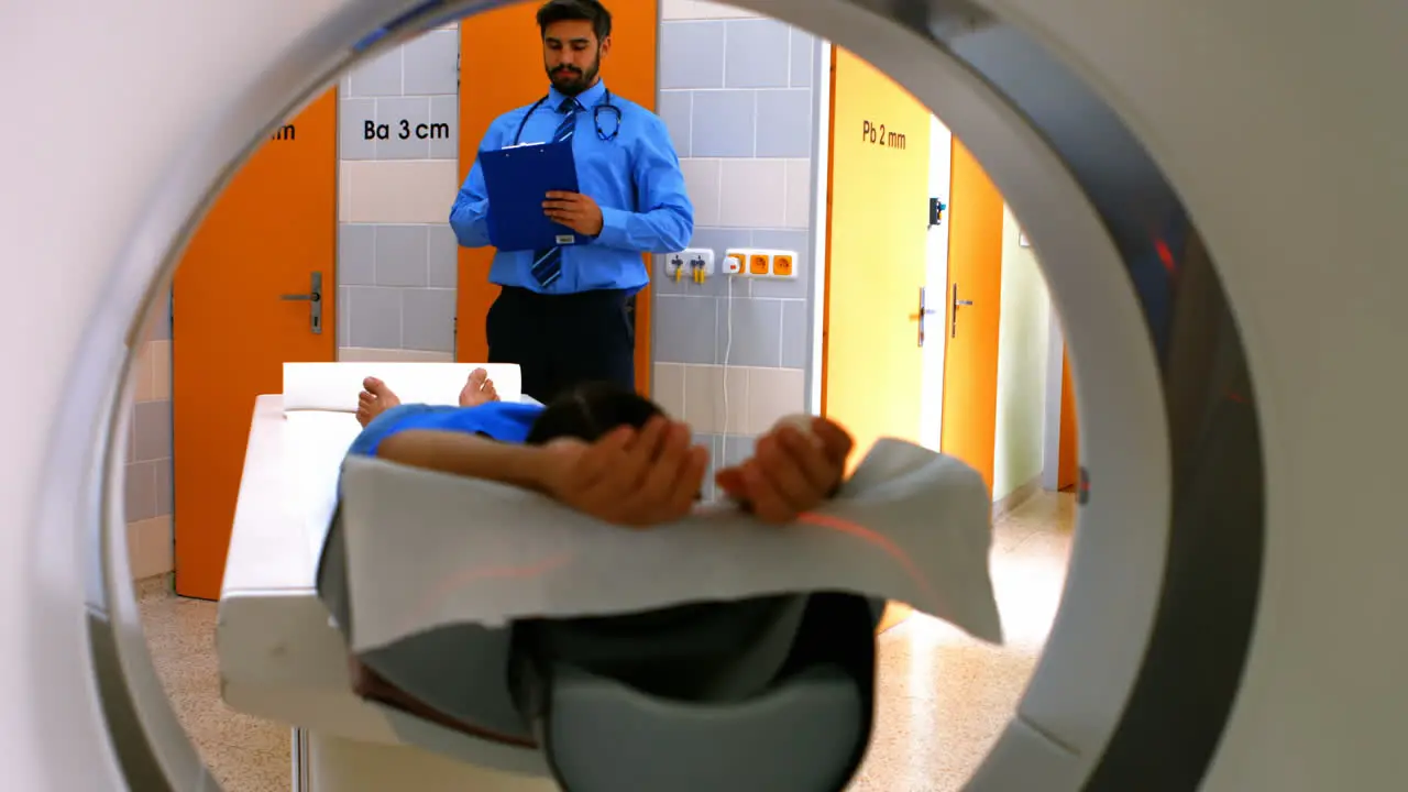 Doctor reviewing chart of patient about to have mri scan