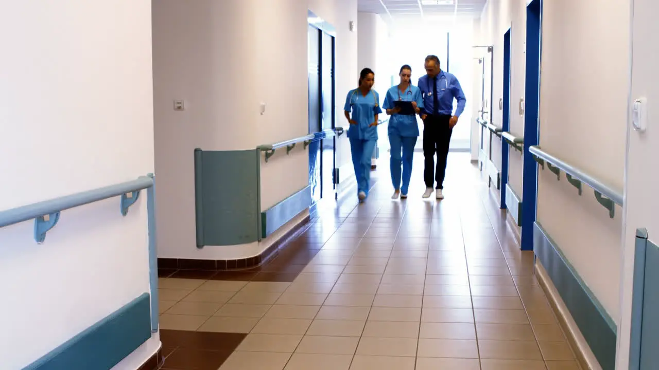 Doctor and nurses discussing over clipboard