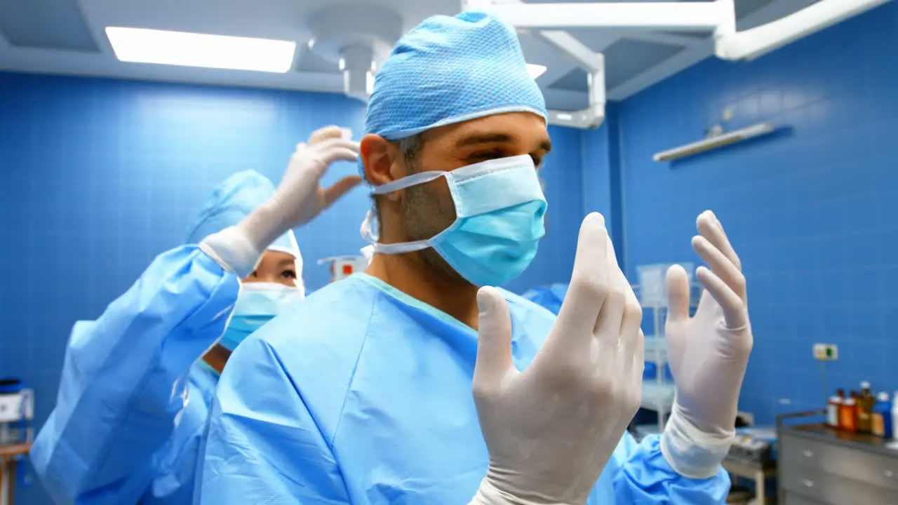 Nurse helping a surgeon in tying surgical mask