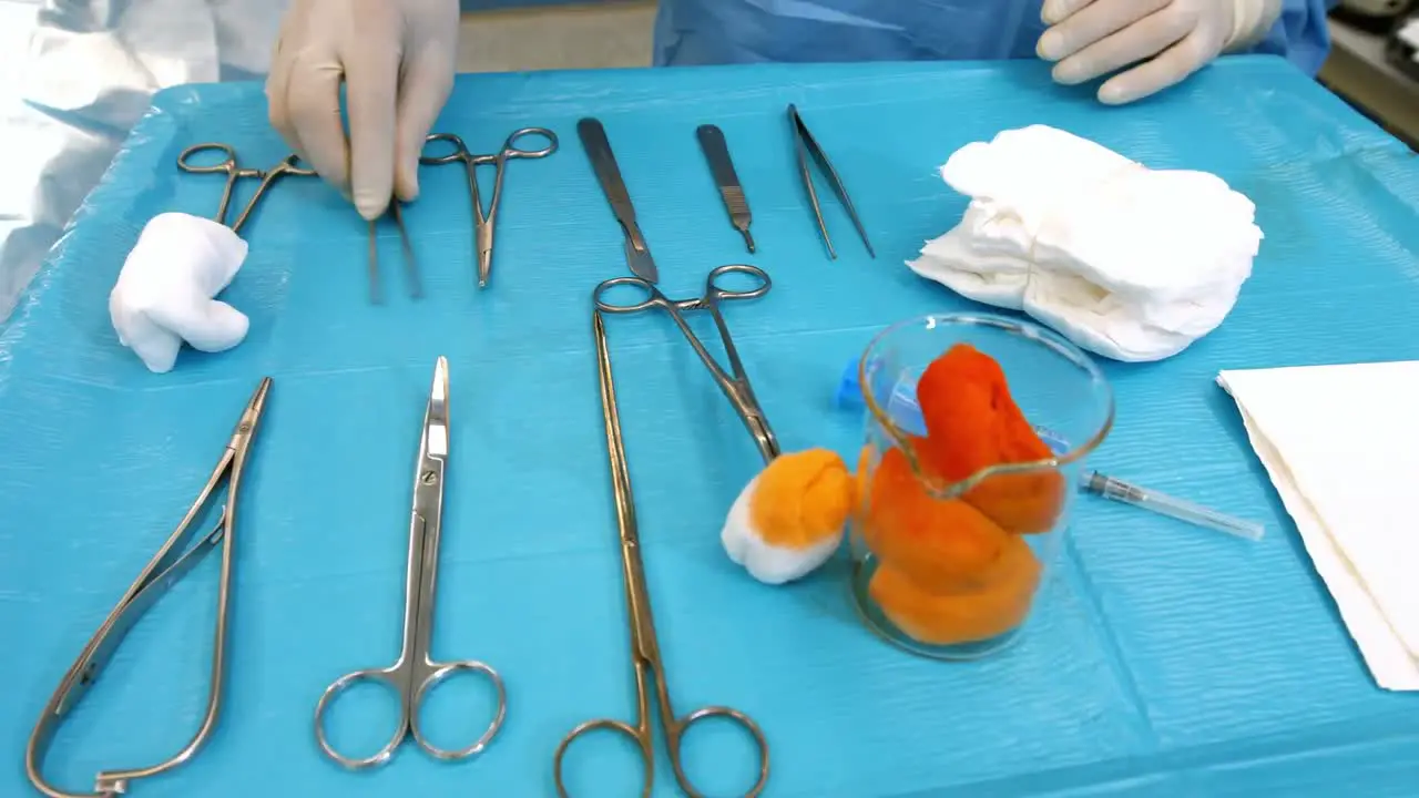 Surgeon arranging surgical tools on surgical tray in operation room