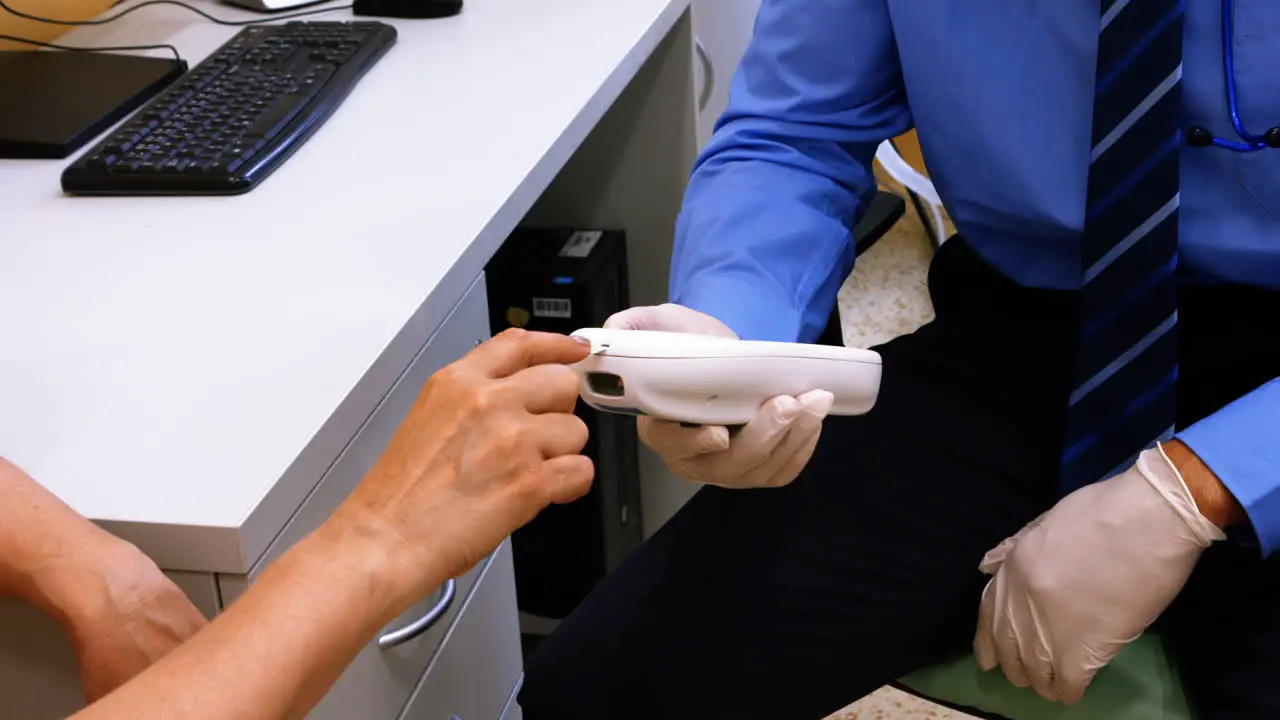 Doctor measuring sugar level of patient with glucometer