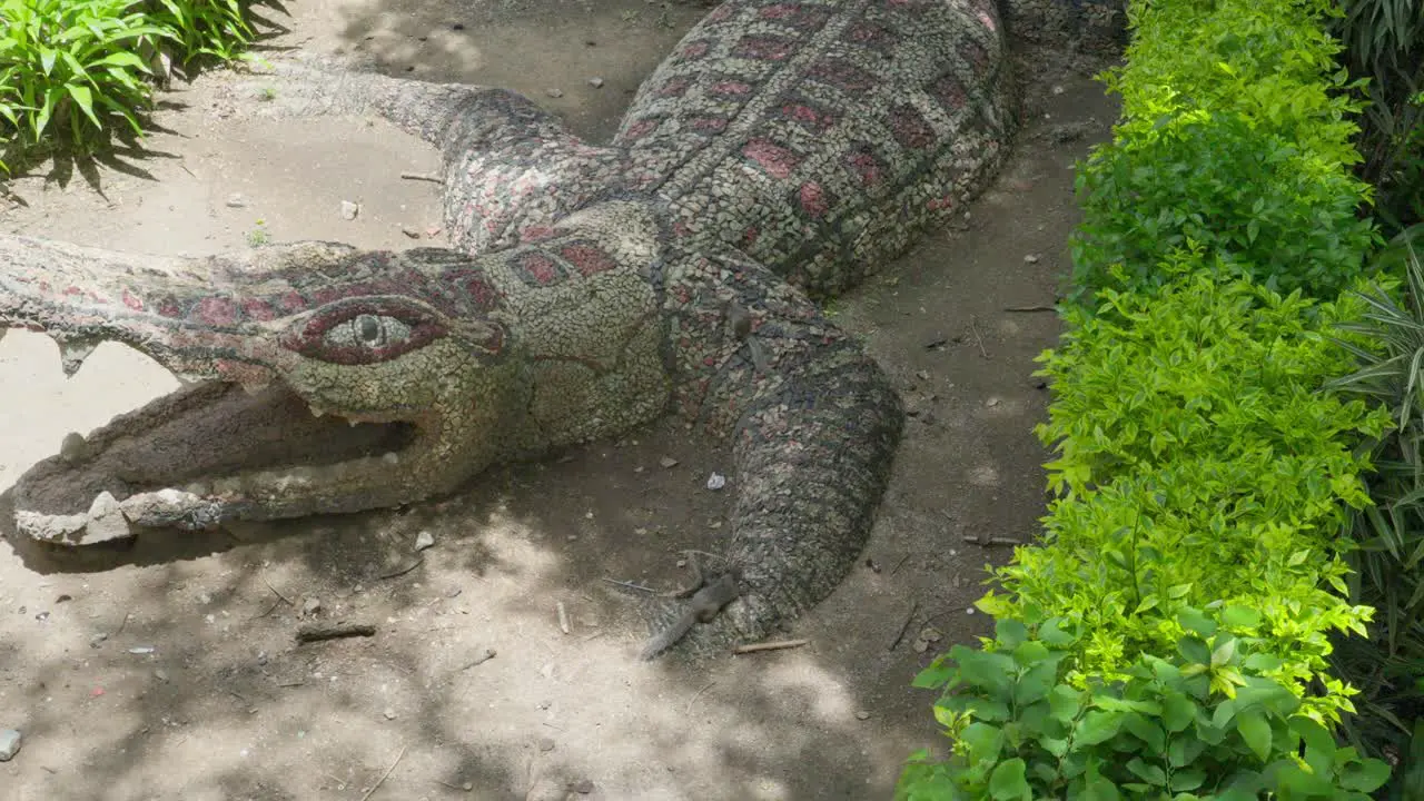 Two squirrel climbing up a sculpture of a crocodile