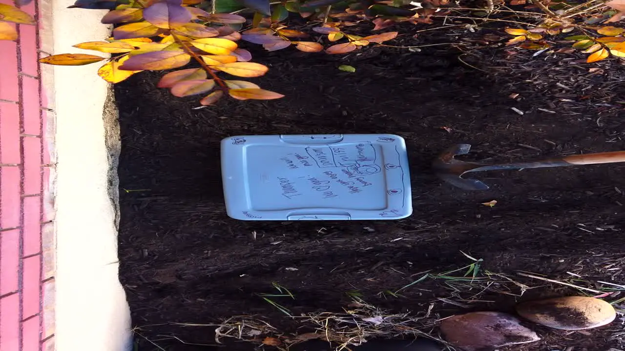 Measuring out the size of hole with a shovel for a recently deceased pet inside of a small plastic case