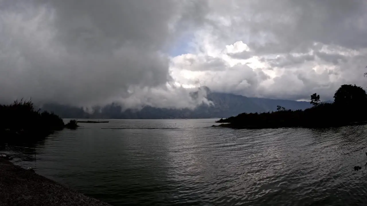 Timelapse of vapor clouds rolling over lake at dusk Kintamani Bali