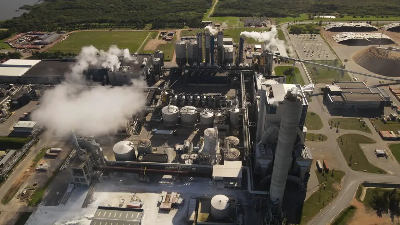 Smoke pollution from paper mill factory rotating aerial view