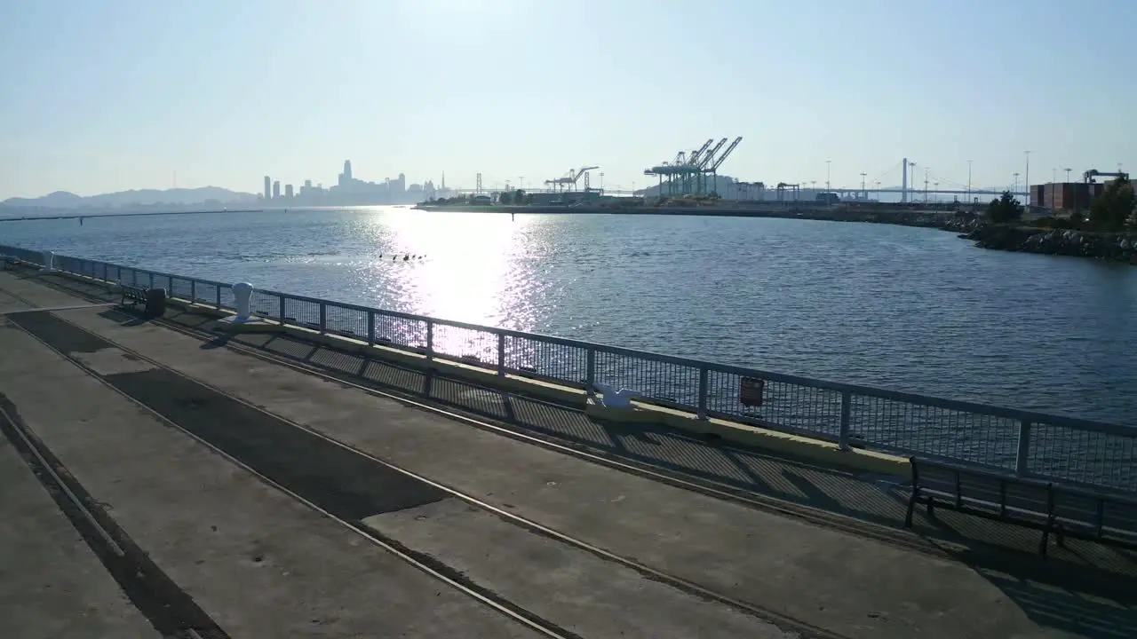 Smooth slide left with large shipping cranes in the distance in San Francisco California on a sunny day in October