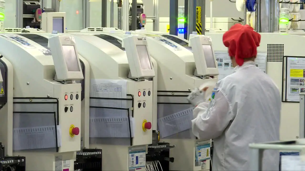 medium shot woman working inside an it company wearing white coat and red hat