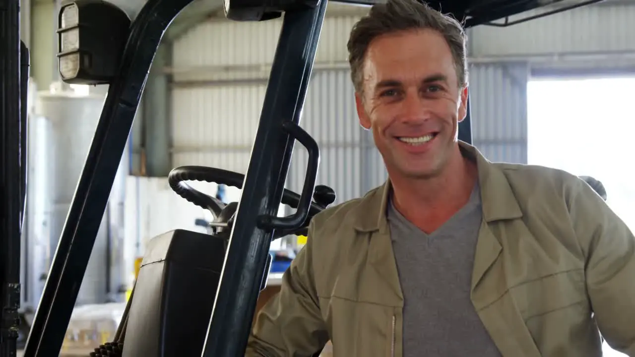 Portrait of happy worker standing near forklift 4k