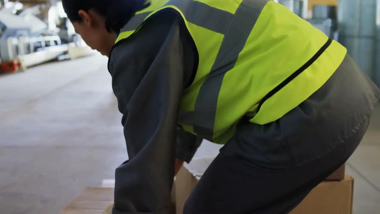 Female worker suffering from back pain while holding heavy box 4k