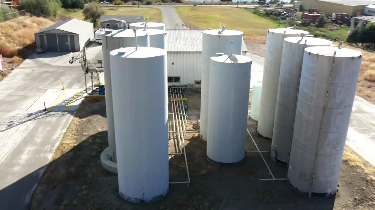 Aerial Orbit Shot over Bulk plants with large white Flat-bottom tanks capacity of up to 1 million litres Fuels like Diesel and Gasoline in a Desert Environment