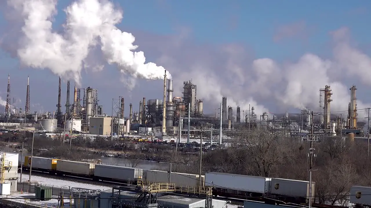 Oil Refinery Polluting The Air With Global Warming As Train Rolls By