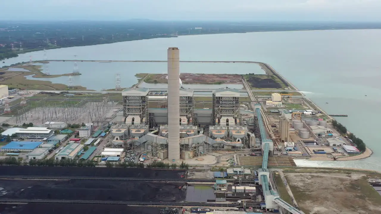 Industrial aerial shot of coastal coalfield ultra-supercritical coal-fired power plant with smokes raising from chimney located at lekir bulk terminal jalan teluk rubiah manjung perak malaysia