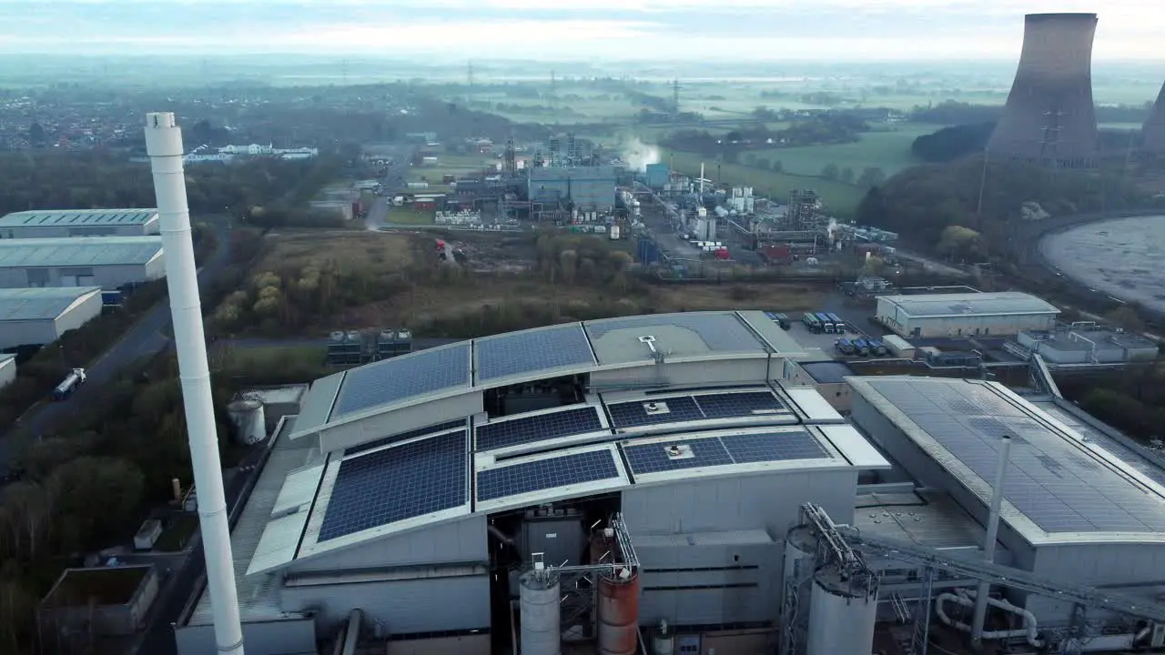 Futuristic solar green energy factory rooftop on foggy rural countryside morning aerial view close up to pull away shot