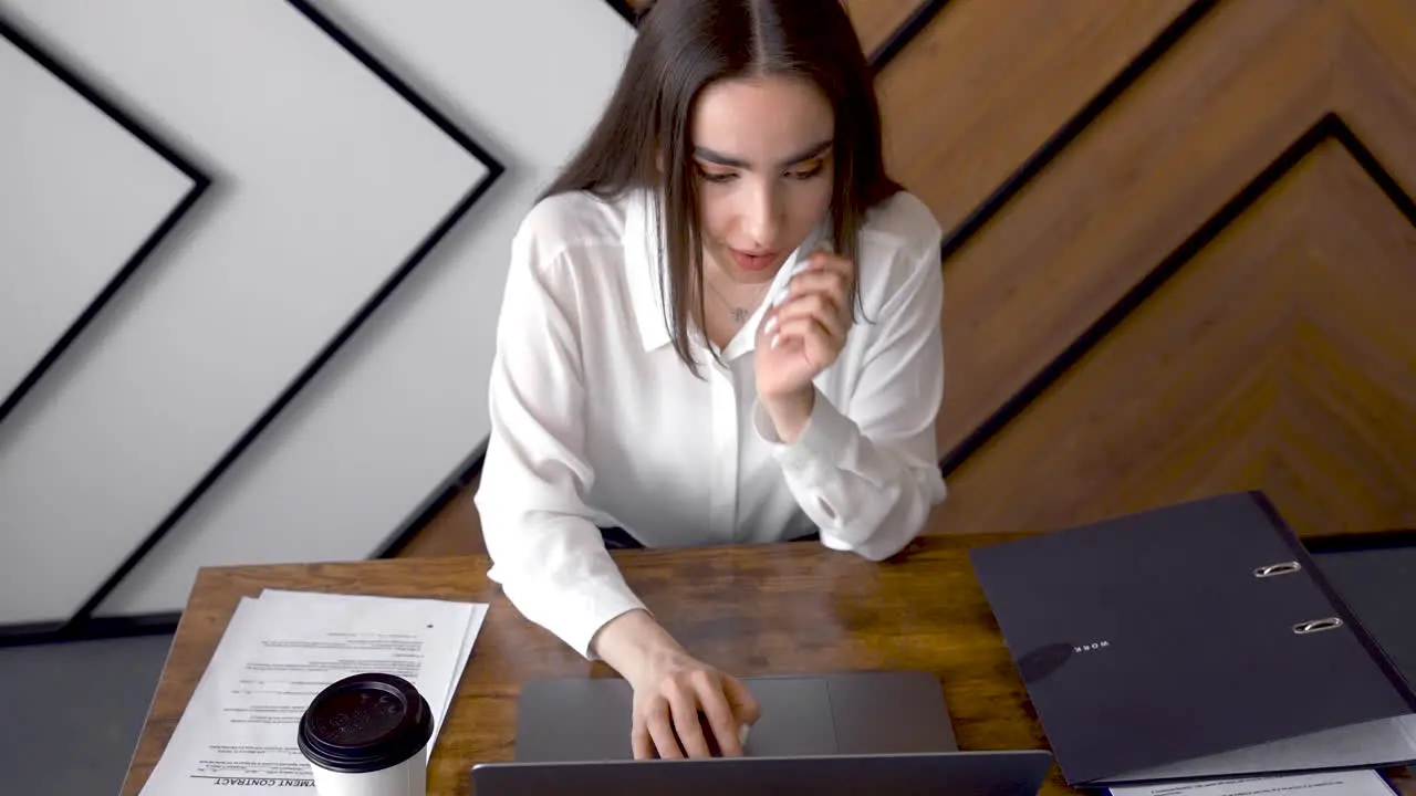 A Woman Is Working With Her Laptop In An Office 3