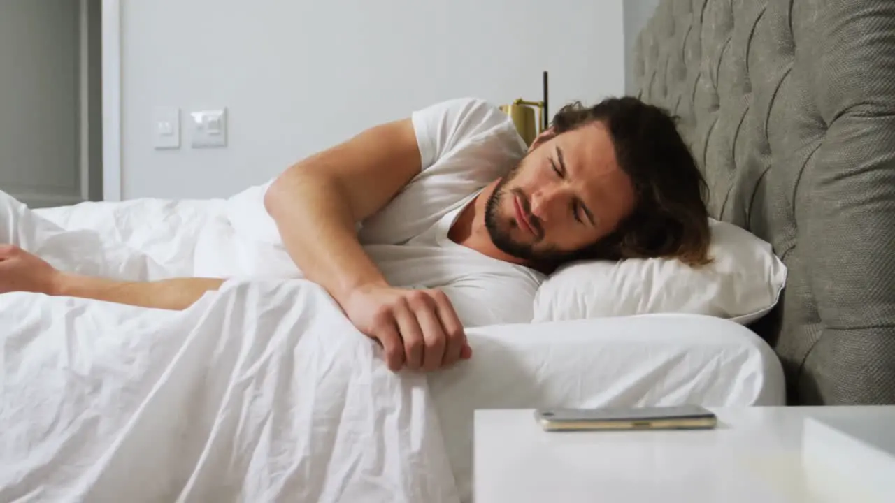 Man checking his mobile phone in bedroom