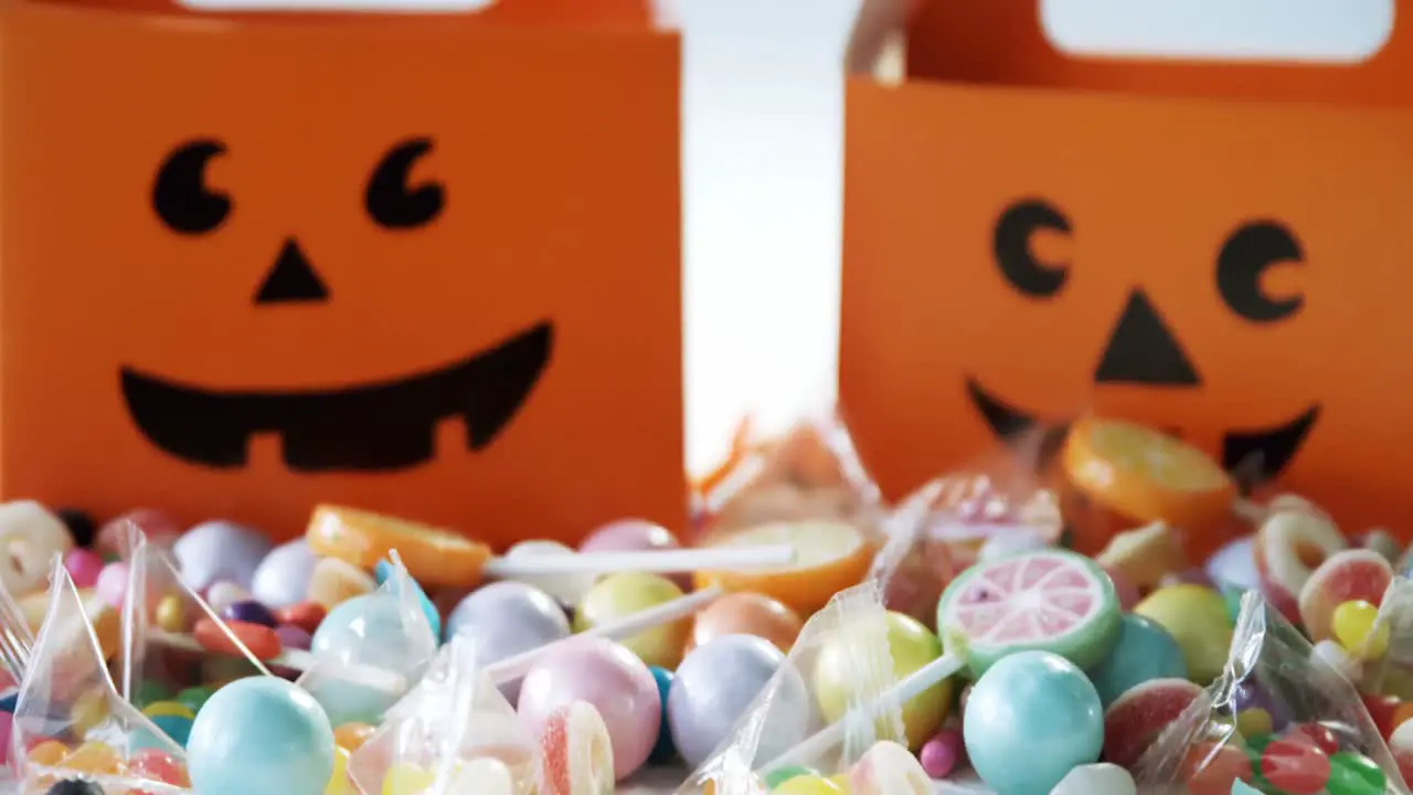 Halloween box with various candies on white background 4k